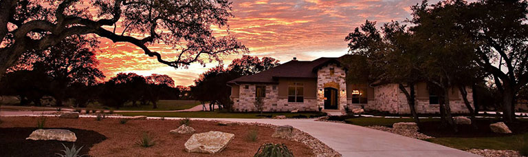 Picture of the outside of a custom built home in the evening.